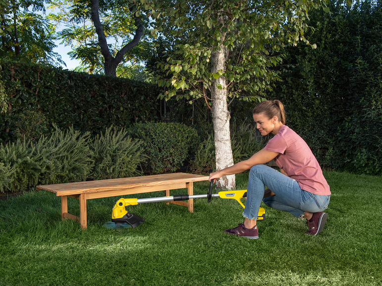 Eine Frau verwendet einen Gardena Rasenmäher im Garten.