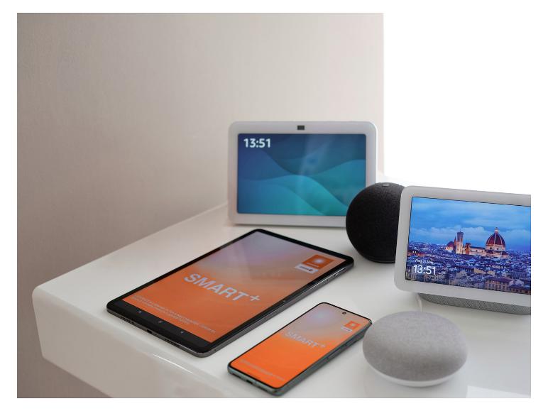 Smart-Home-Geräte, darunter Smart Displays, ein Tablet und ein Smartphone auf einer weißen Oberfläche.