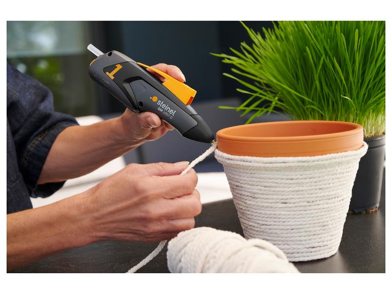 Frau benutzt eine STEINEL Heißklebepistole, um einen Blumentopf mit Seil zu verzieren.