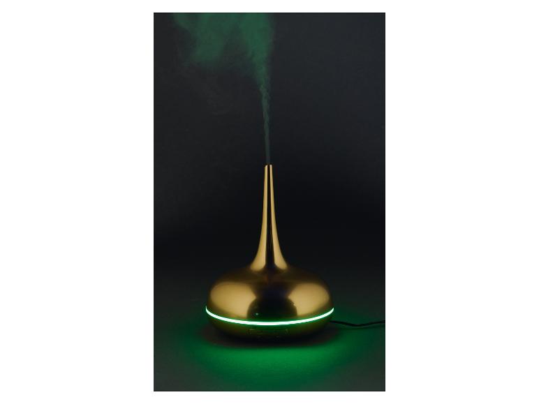 Goldener Aroma-Diffusor mit grünem Licht und Rauch auf dunklem Hintergrund