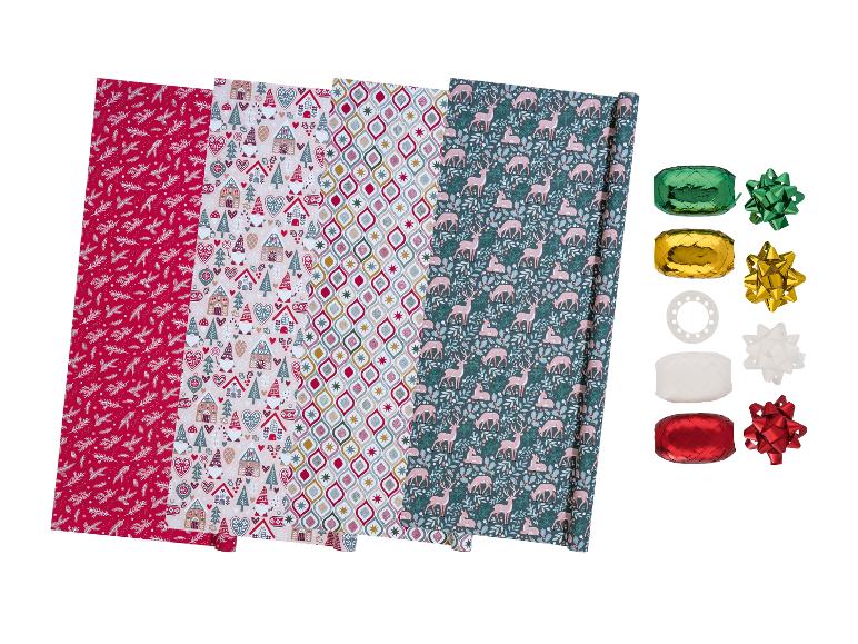 Vier Rollen weihnachtliches Geschenkpapier mit passenden Bändern.