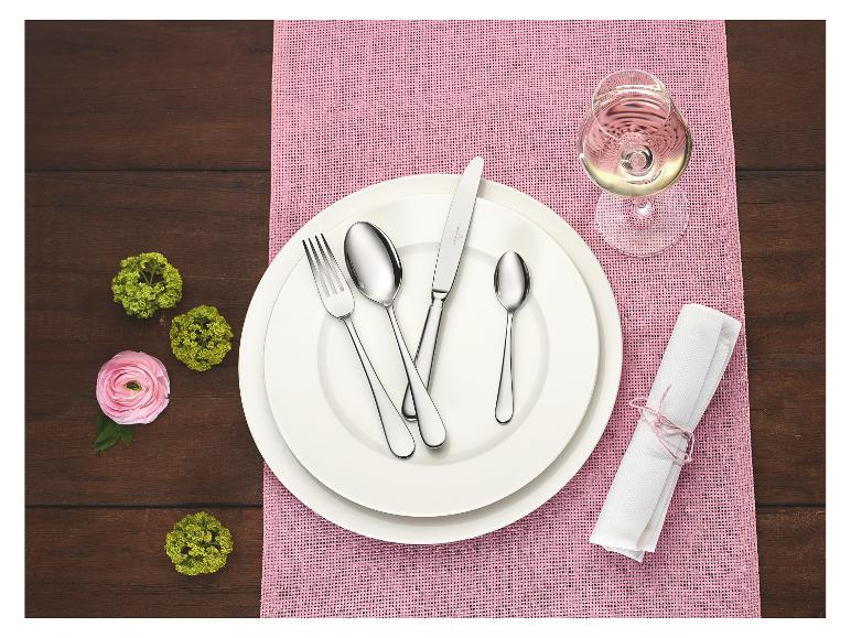 Elegante Tischdekoration mit weißen Tellern, Besteck, einem Glas Weißwein und rosa Akzenten.