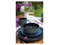 Tischgedeck mit dunkelblauen und schwarzen Keramikgeschirr, frischen Blaubeeren und Weißwein.