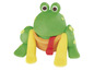 Ein grüner Frosch aus Knete mit gelben Beinen und einem roten Band.