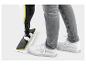 Person reinigt Boden mit Dampfmopp, trägt graue Jeans und weiße Sneaker.