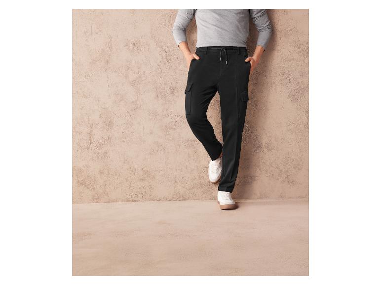 Schwarze Cargohose mit weißen Sneakers.