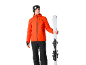 Mann in orangefarbener Skijacke und schwarzer Skihose mit Skiern.