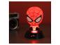 Rot leuchtende Spiderman-Nachtlampe auf schwarzem Sockel, mit unscharfer Kamera im Hintergrund.