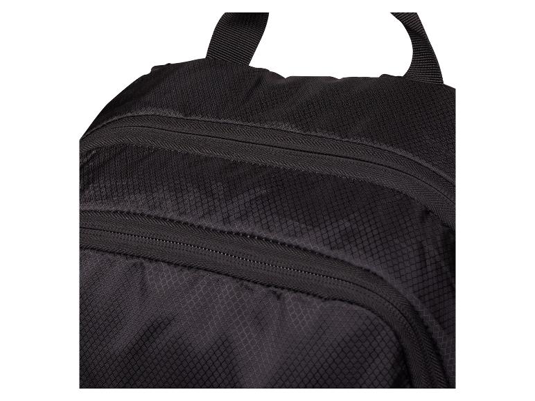 Detail eines schwarzen Rucksacks mit Reißverschlüssen und Rautenmuster.
