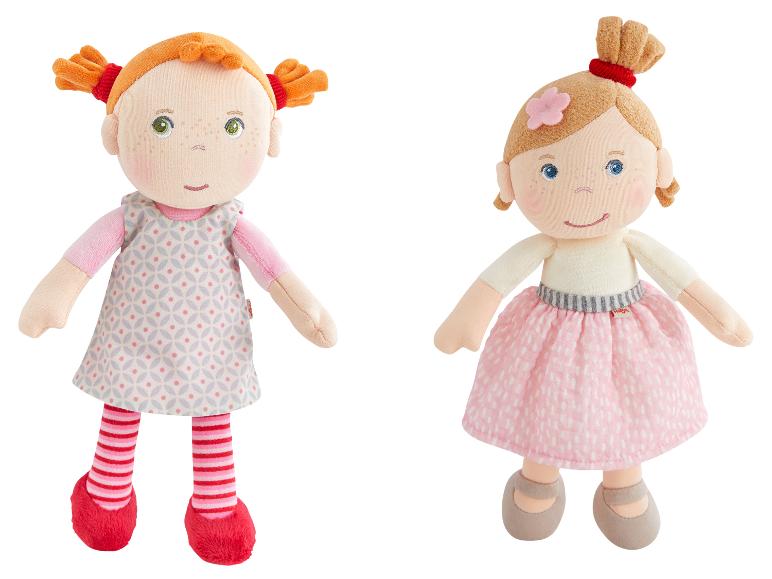 Zwei Plüschpuppen, eine mit roten Haaren und gemustertem Kleid, die andere mit blonden Haaren und rosa Rock.