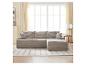 Graues Modulsofa mit Kissen in einem hellen Wohnzimmer mit großen Fenstern und Vorhängen.