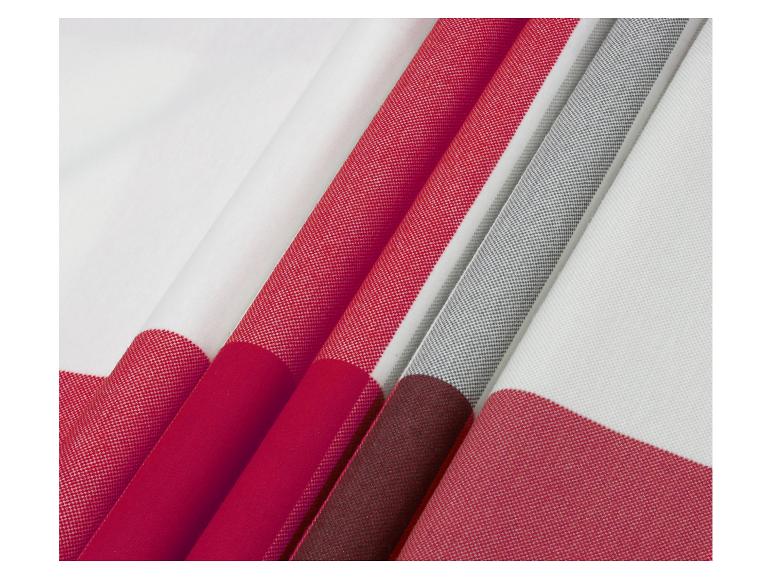 Gefaltete Textilien in Weiß, Rot, Grau und Bordeaux mit verschiedenen Texturen.