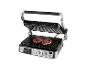 Elektrischer Grill mit zwei Steaks, die auf den Rosten garen, mit offenem Deckel und Bedienfeld.