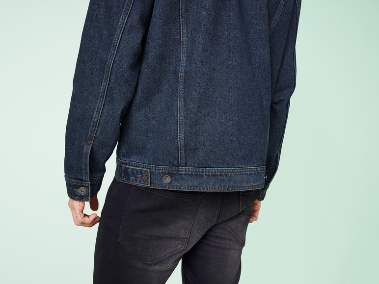 Eine dunkelblaue Jeansjacke und schwarze Jeans.
