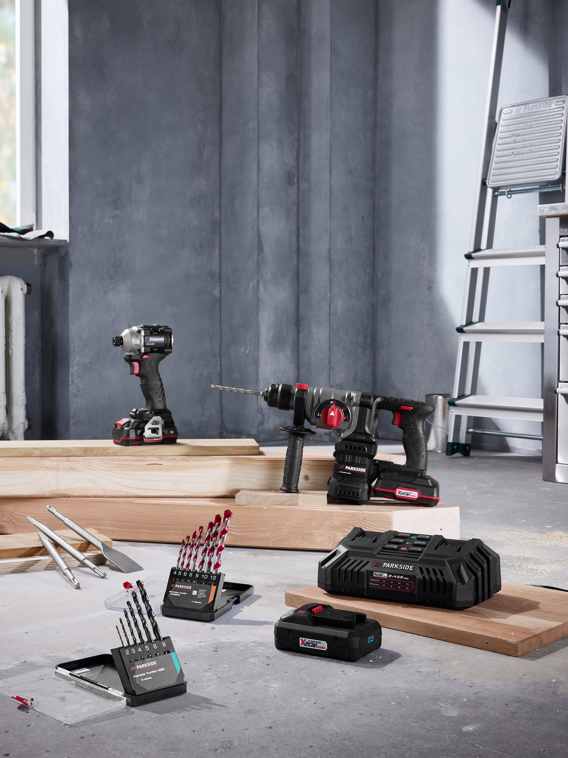 Parkside Elektrowerkzeuge mit Bohrmaschinen, Bohrern und Ladegerät in einer Baustellenumgebung.
