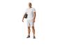 Mann in T-Shirt und Shorts mit Fitnessball.