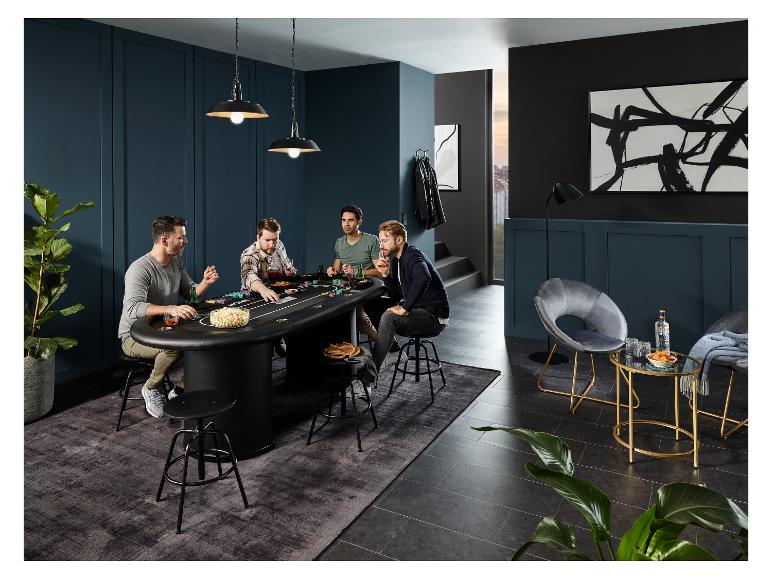 Vier Männer spielen Poker an einem schwarzen Pokertisch mit hohen Stühlen.