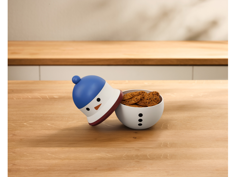 Schneemannförmige Keksdose gefüllt mit Keksen auf einem Holztisch.