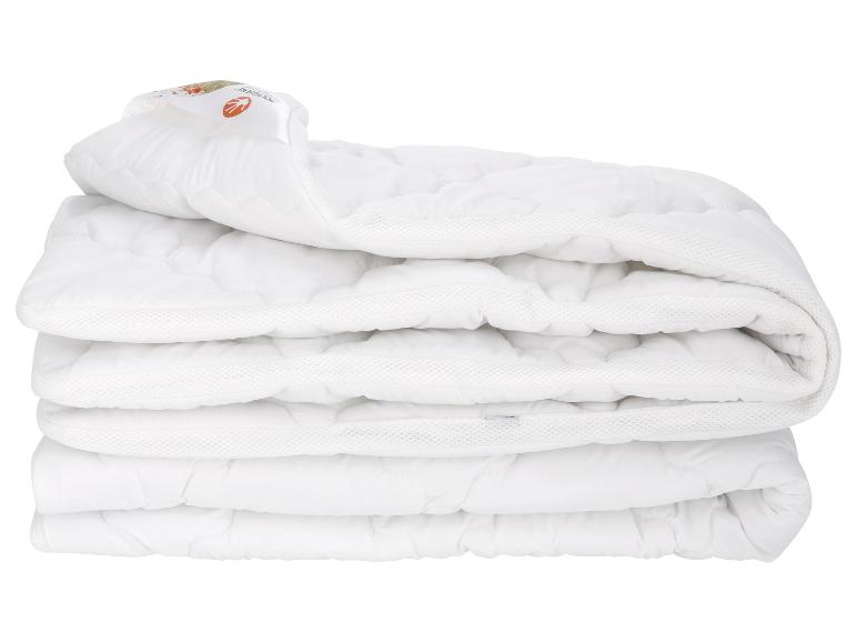 Eine gefaltete weiße, gesteppte Matratzenauflage.