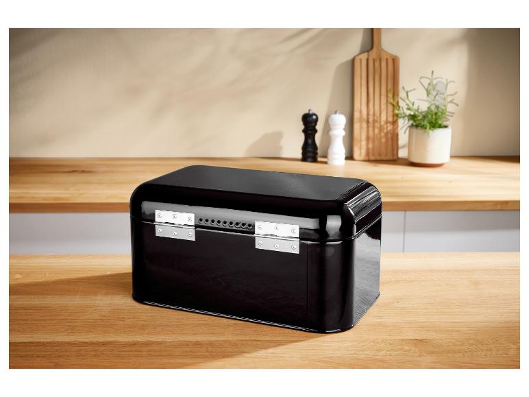 Schwarze Metall-Brotschachtel auf einem Holztisch in einer Küche.