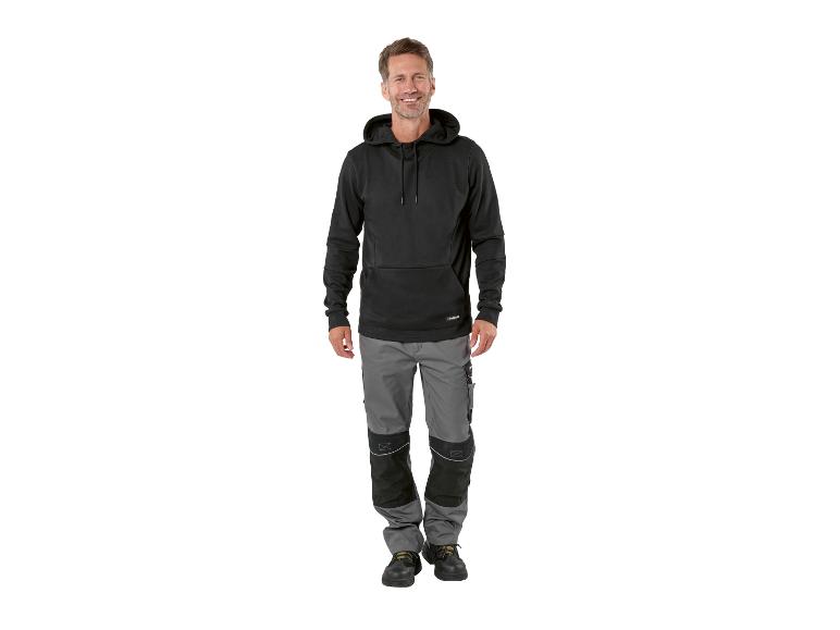 Mann in schwarzem Hoodie und grauer Arbeitshose
