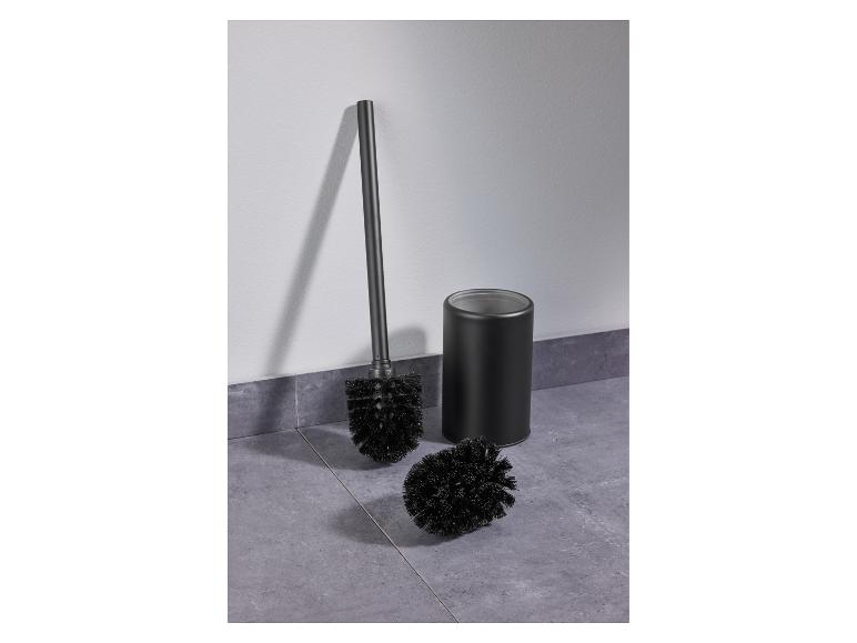 Schwarzes WC-Bürsten-Set auf einem grauen Fliesenboden.