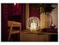 LIVARNO® LED-Kerze im Metallkorb auf einer Holzkommode mit Vase und Büchern.