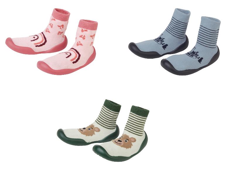 Drei Paar Babyschuhe mit verschiedenen Designs.