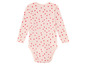 Ein rosa Baby-Body mit langen Ärmeln und einem Herzchenmuster.
