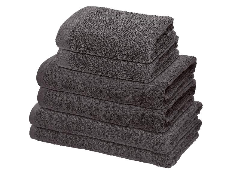 Stapel gefalteter grauer Handtücher in verschiedenen Größen.