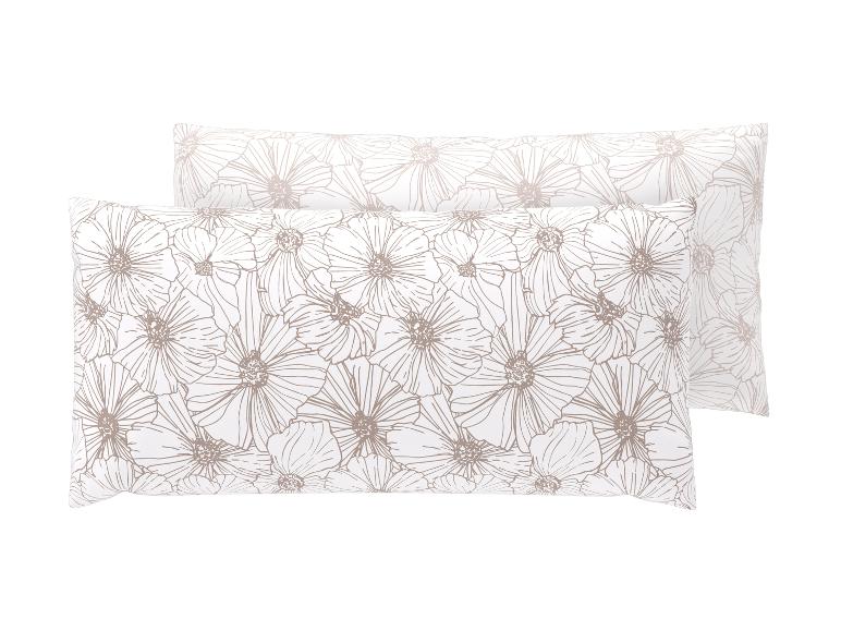 Zwei weiße Kissen mit beigem Blumenmuster.