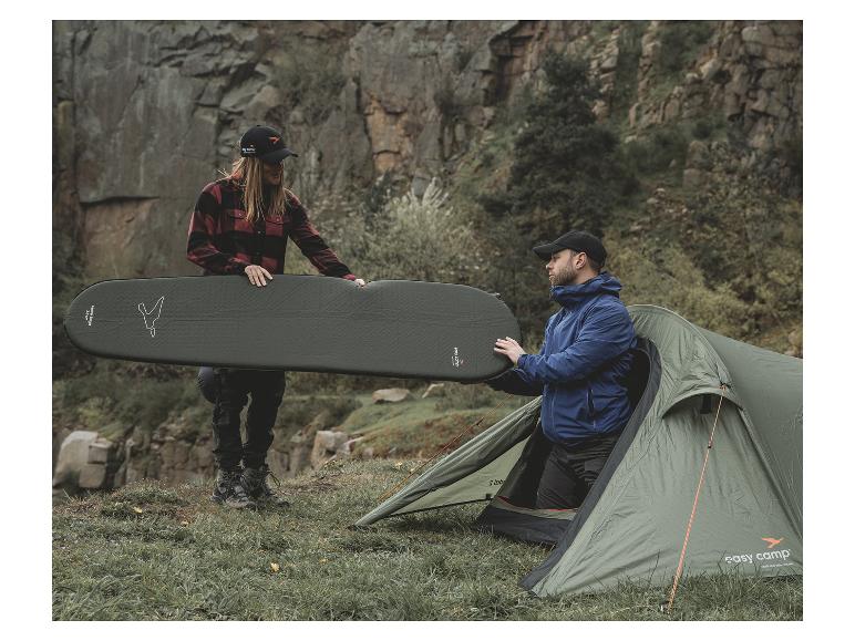 Ein grünes Easy Camp Zelt und eine aufblasbare Isomatte werden für den Camping vorbereitet.