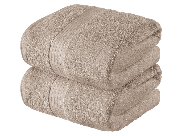 Zwei beige Handtücher, gefaltet.