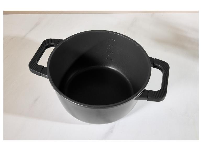 Schwarzer Kochtopf mit Griffen und Messmarkierungen auf weißer Oberfläche