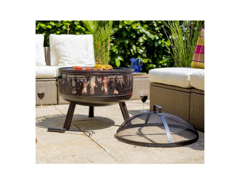 Feuerschale mit Grillfunktion und Essen, umgeben von Gartenmöbeln und Pflanzen.