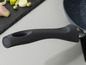 Eine schwarze Pfanne mit einem Soft-Touch-Griff.