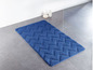Eine blaue Badezimmermatte mit Zickzackmuster in einem Badezimmer.