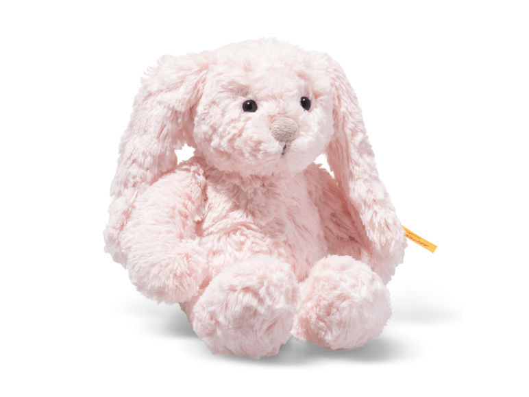 Plüschiger rosa Hase sitzend auf weißem Hintergrund