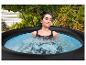 Frau entspannt sich in einem Outdoor-Whirlpool, umgeben von Grün.