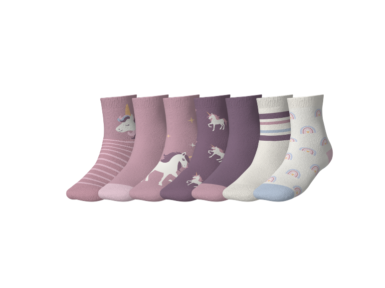 Sieben Paar Kinderstrümpfe in Rosa, Lila und Weiß mit Einhorn- und Regenbogenmustern.