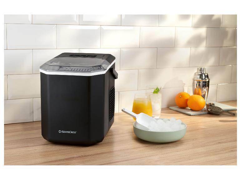 Schwarze Eismaschine mit Eis, Getränken und Cocktailshaker auf einer Holztheke.