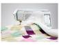 Nähmaschine quiltet eine bunte Patchworkdecke