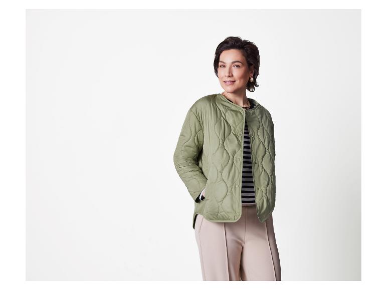 Frau in grüner Steppjacke und beige Hose.