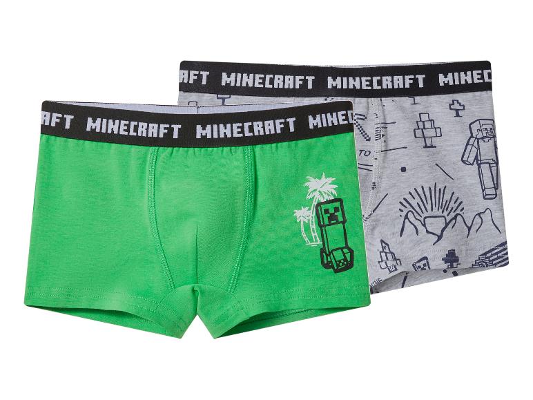 Zwei Jungen-Boxershorts, eine grüne mit Monster-Motiv, eine graue mit Charakter-Prints.