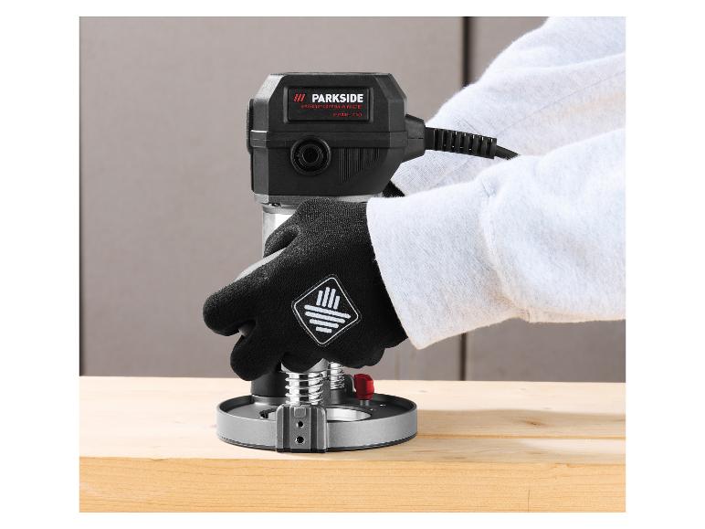Person mit Handschuhen benutzt eine Parkside Performance Oberfräse auf einem Holzbrett