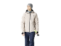 Mann in beiger Skijacke, dunkelblauer Hose und grauer Mütze, hält Skistöcke.