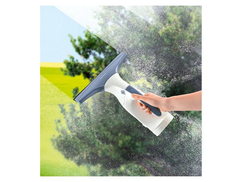 Hand hält Fenstersauger, reinigt Fenster mit klarer Sicht nach draußen