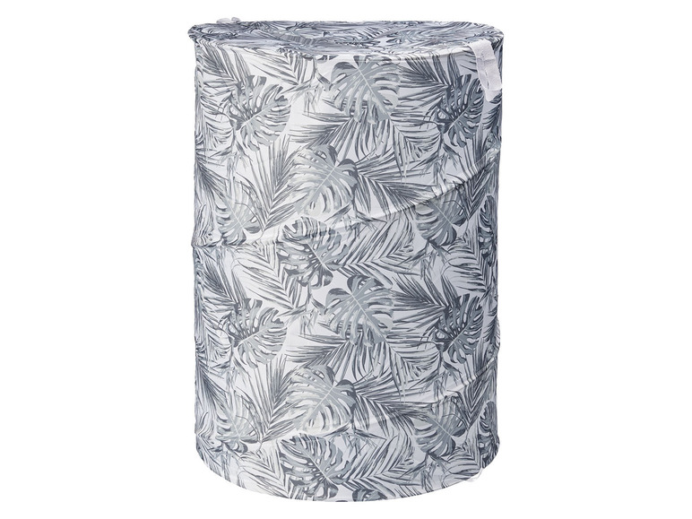 Ein runder Wäschekorb mit tropischem Blättermuster.