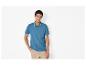 Mann in blauem Poloshirt und beiger Hose, posiert mit Hand in der Tasche.