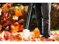Mann benutzt einen Laubbläser, um Herbstlaub zu entfernen.
